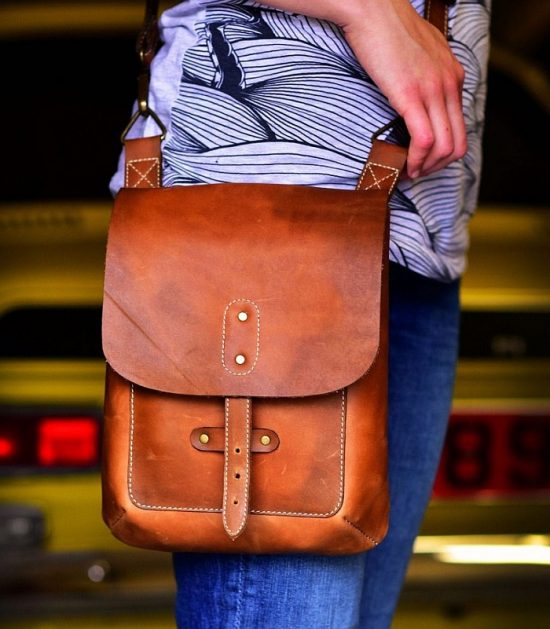 brown leather cross body bag close up worn on a model